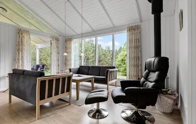 a living room with a couch and a table and chairs at Holiday Home Kjeldhøj Farsø Xi in Farsø