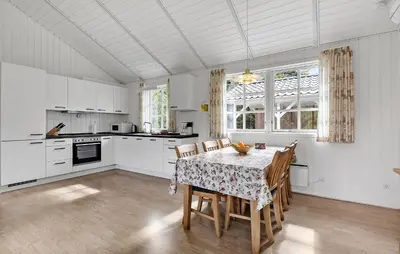 a kitchen with a table and chairs in a room at Holiday Home Kjeldhøj Farsø Xi in Farsø