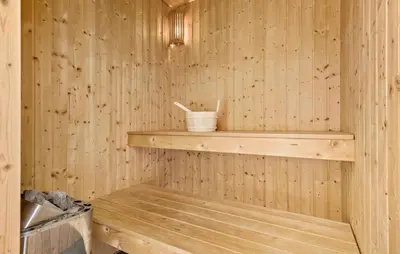 a wooden sauna with a wooden shelf and a bucket at Amazing Home In Løgstør With Kitchen in Løgstør