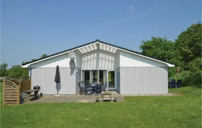 a white barn with a picnic table and chairs at Holiday Home Illeris Farsø Ix in Farsø