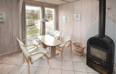 a room with a wood stove and a table and chairs at Holiday Home Illeris Farsø Ix in Farsø