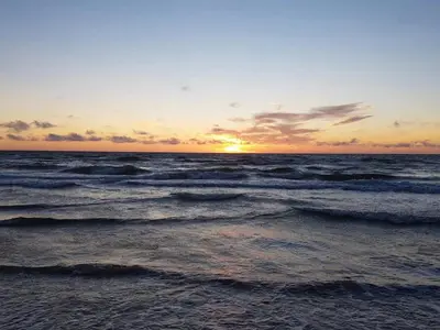 a sunset over the ocean with waves at 6 person holiday home in Brovst-By Traum in Brovst