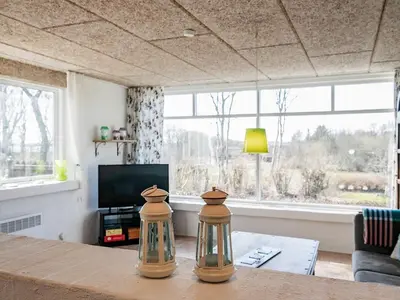 a living room with a table with two glass vases on it at 6 person holiday home in Farsø-By Traum in Farsø