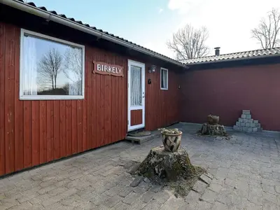 a red building with a sign that says unhappy on it at 6 person holiday home in Farsø-By Traum in Farsø