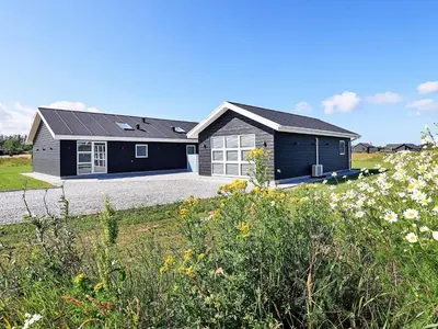 a large black house with a driveway at 10 person holiday home in Løkken-By Traum in Løkken