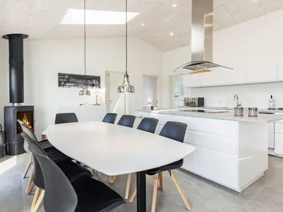 a kitchen and dining room with a white table and chairs at 10 person holiday home in Løkken-By Traum in Løkken