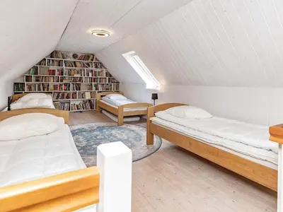 a attic bedroom with two beds and a book shelf at 12 person holiday home in Thisted-By Traum in Thisted