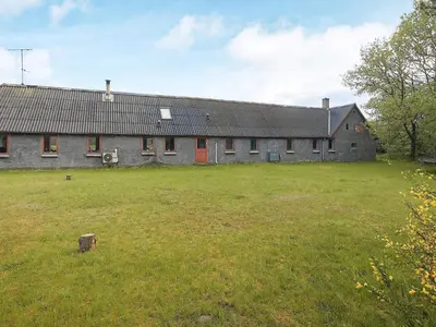 a large stone building with a grass field in front of it at 12 person holiday home in Thisted-By Traum in Thisted