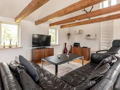 a living room with a leather couch and a table at 12 person holiday home in Thisted-By Traum in Thisted