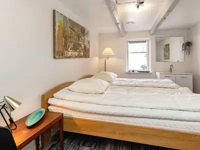a bedroom with a large bed and a wooden table at 12 person holiday home in Thisted-By Traum in Thisted