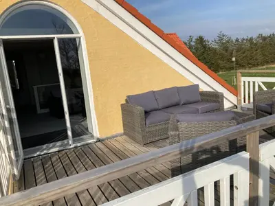 a couch sitting on a deck on a house at Idyllic country house in Vadum