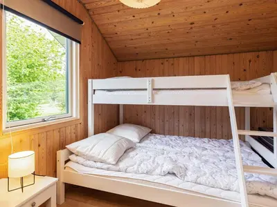 a bedroom with bunk beds in a wooden cabin at 8 person holiday home in Højslev-By Traum in Højslev