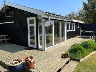 a deck with sliding glass doors on a house at 6 person holiday home in Thyholm-By Traum in Thyholm