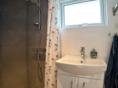 a bathroom with a sink and a shower with a window at 6 person holiday home in Thyholm-By Traum in Thyholm