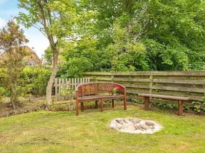 a wooden bench sitting in a yard next to a fence at 8 person holiday home in Struer-By Traum in Struer