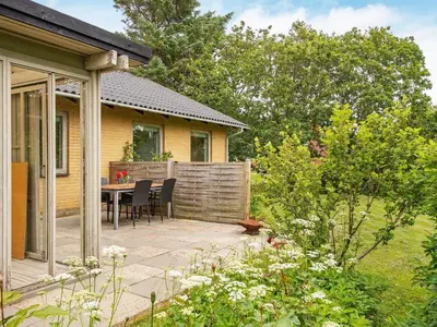 a patio with a table and chairs in a garden at 8 person holiday home in Struer-By Traum in Struer