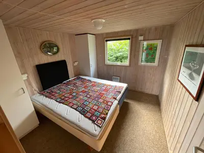a small room with a bed in a house at Ældre Sommerhus Max 4 voksne og 4 børn in Lemvig
