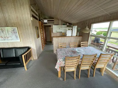 a dining room and kitchen with a table and chairs at Ældre Sommerhus Max 4 voksne og 4 børn in Lemvig