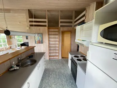 a kitchen with a sink and a stove at Ældre Sommerhus Max 4 voksne og 4 børn in Lemvig