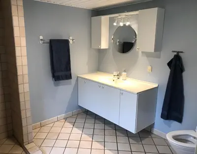 a bathroom with a sink and a mirror and a toilet at Sommerhus på Mors in Øster Assels