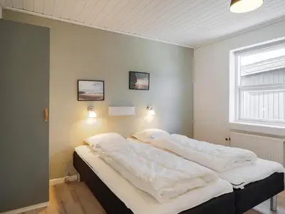 a bedroom with a bed with white sheets and a window at Renovated Retreat with Pool - By Traum Ferienwohnungen in Thisted