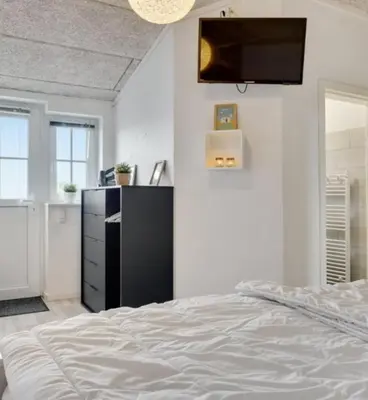 a bedroom with a bed and a tv on the wall at Cold Hawaii in Torsted