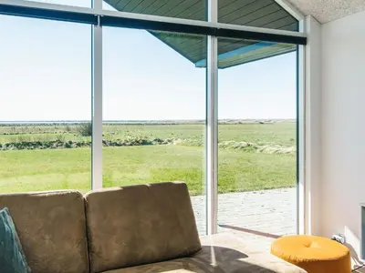 a living room with a couch and a large window at Luxury Retreat with Pool - By Traum Ferienwohnungen in Harboør