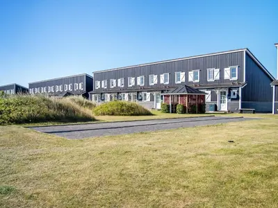 a large building with a field in front of it at 6 person holiday home in Vestervig-By Traum in Vestervig