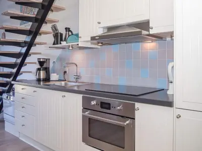 a kitchen with white cabinets and a blue tiled wall at 6 person holiday home in Vestervig-By Traum in Vestervig