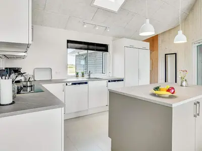 a kitchen with white cabinets and a bowl of fruit on the counter at Luxury Retreat for 18 - By Traum Ferienwohnungen in Spottrup