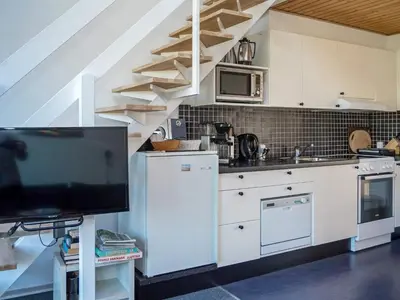 a kitchen with white cabinets and a tv in it at 6 person holiday home in Vestervig-By Traum in Vestervig