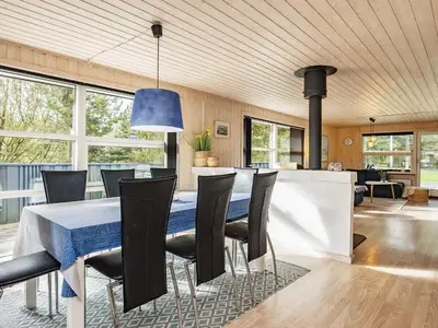 a dining room with a blue table and chairs at 8 person holiday home in Blokhus-By Traum in Blokhus