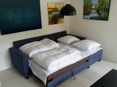 a blue bed with white sheets and pillows on it at Airbnb-lejligheder, Villerslev in Villerslev