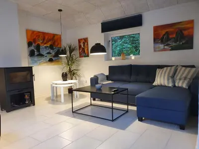a living room with a blue couch and a tv at Airbnb-lejligheder, Villerslev in Villerslev