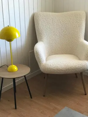 a yellow lamp next to a chair and a side table at Seaside Top in Thisted