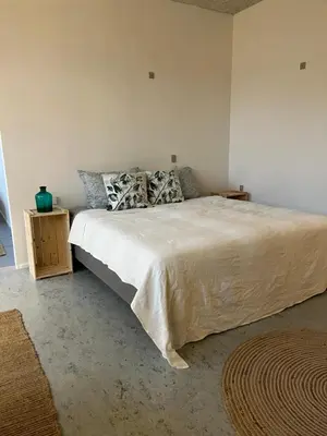 a bedroom with a large bed with white sheets and pillows at Room 6 - Hawkraft Kulturhotel in Vestervig