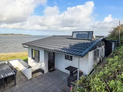 a house with a roof with a view of the water at 4 person holiday home in Farsø-By Traum in Farsø