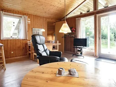 a living room with a table and chairs and a television at Cozy Cottage near Blokhus - By Traum Ferienwohnungen in Blokhus