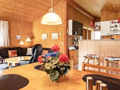 a room with a table with a vase of flowers on it at Cozy Cottage near Blokhus - By Traum Ferienwohnungen in Blokhus