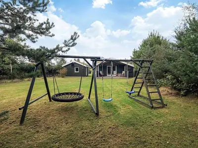 an empty swing set in a yard at Cozy Cottage near Blokhus - By Traum Ferienwohnungen in Blokhus