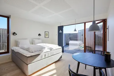 a living room with a bed and a table at Vesterlandet in Vestervig
