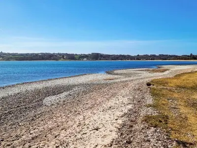 a rocky beach with the ocean in the background at 7 person holiday home in Lemvig-By Traum in Lemvig