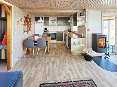 a kitchen with a table and a fireplace in a room at 7 person holiday home in Lemvig-By Traum in Lemvig