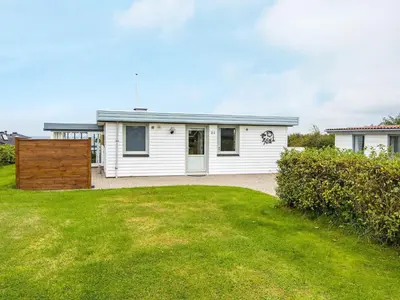 a white house with a lawn in front of it at 7 person holiday home in Lemvig-By Traum in Lemvig