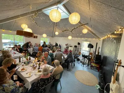a group of people sitting at tables in a restaurant at Room 16 - Hawkraft kulturhotel in Vestervig