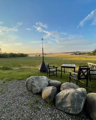 a park with two benches and a table and some rocks at Room 16 - Hawkraft kulturhotel in Vestervig