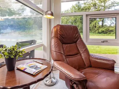 a brown leather chair sitting next to a table at 6 person holiday home in Farsø-By Traum in Farsø