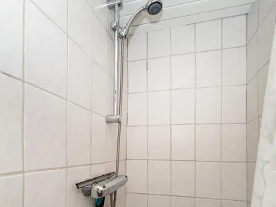 a shower in a bathroom with white tiles at 4 person holiday home in Thisted-By Traum in Thisted