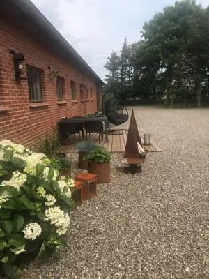 a courtyard of a building with a piano and flowers at Ny Roesgaard in Lemvig