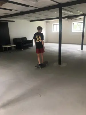 a man standing on a skateboard in a large room at Ny Roesgaard in Lemvig